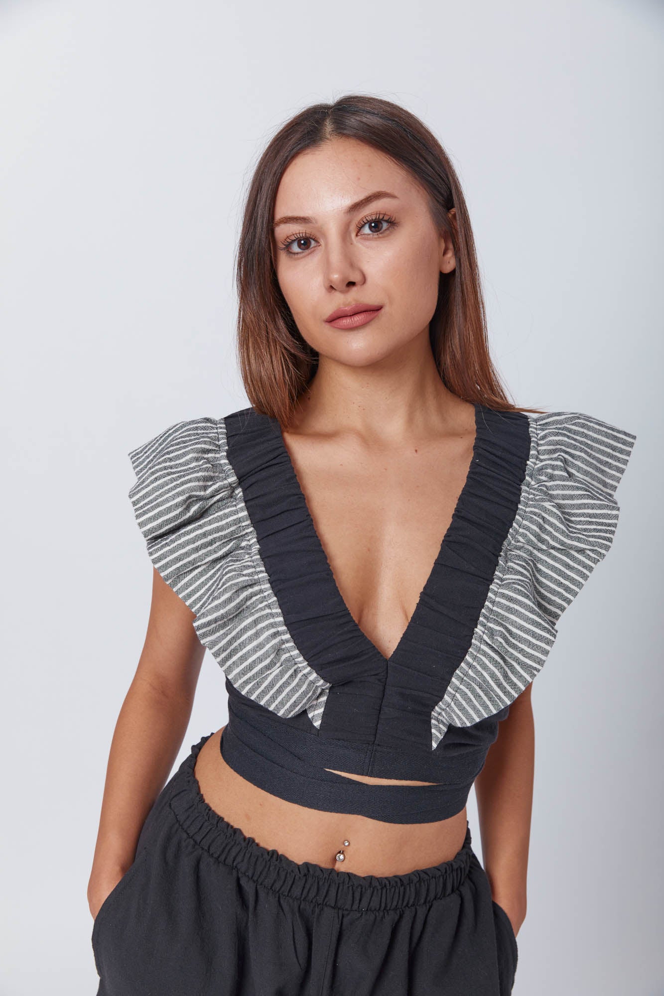 Chic and modern monochrome outfit with soft textures and ruffled contrast, captured in a cropped, editorial-style fashion shot