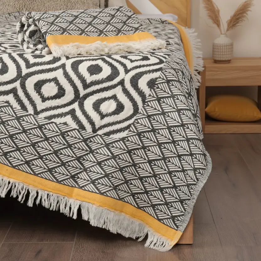 Bed with a patterned quilt and yellow accents in a bedroom setting