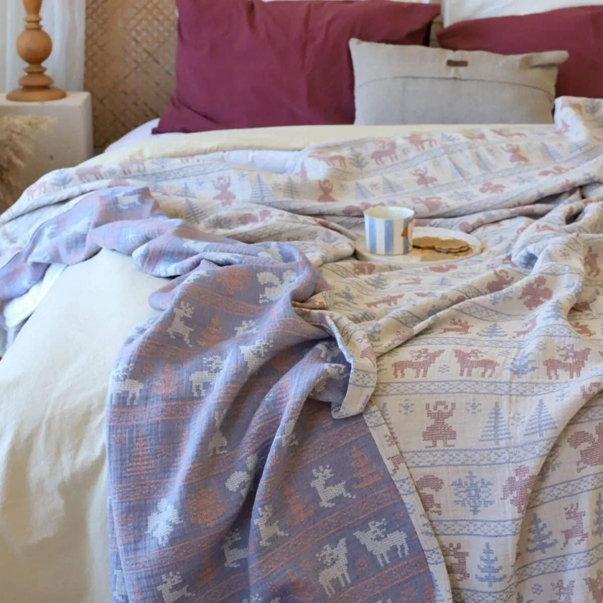 Bed with Trimita Nordic Deer Christmas Bedspread and pillows in a cozy bedroom setting