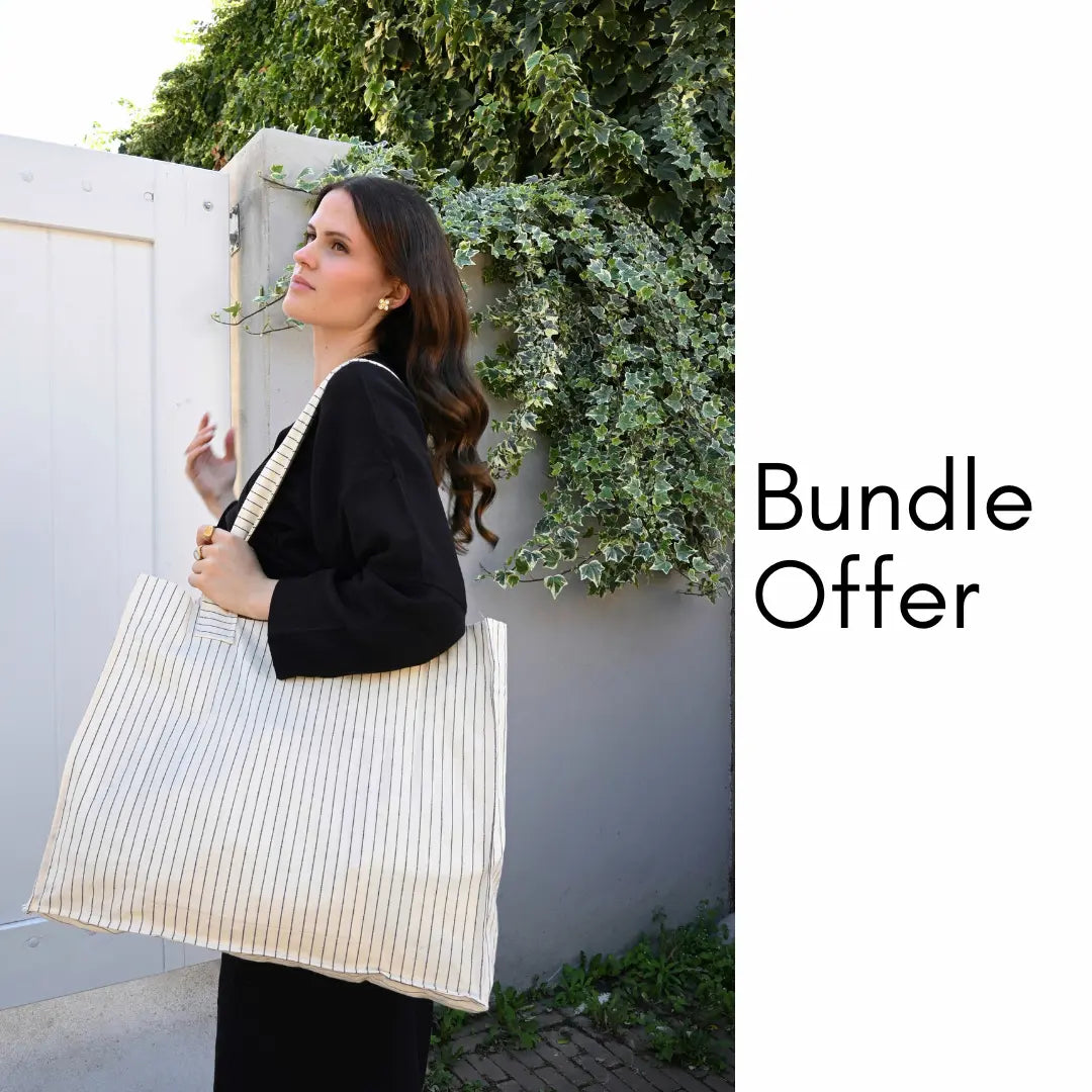 Woman wearing Trimita Saga Black Top and Saga Black Pant,holding a striped tote bag.