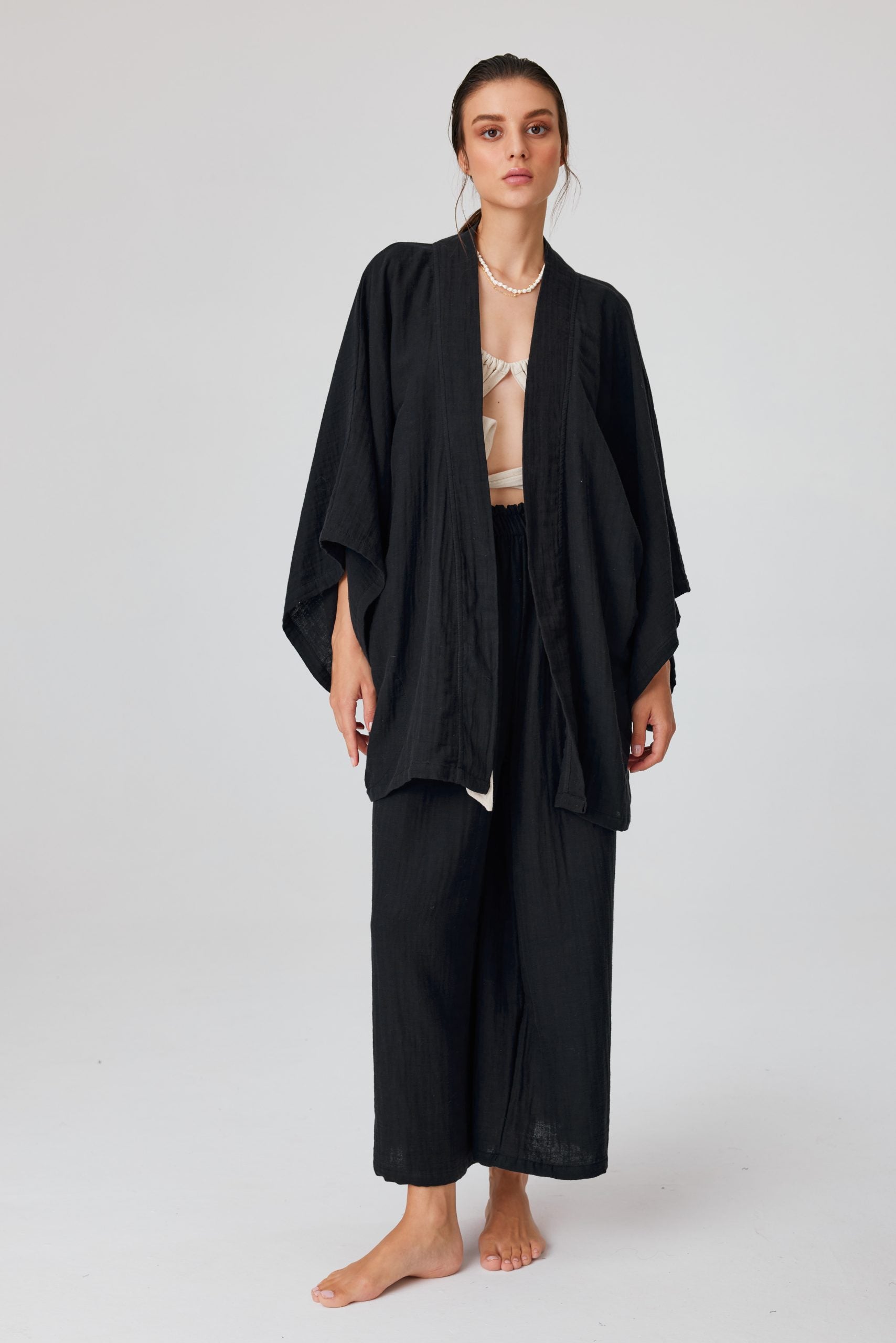 Woman wearing a Trimita Short Kimono Black on a white background