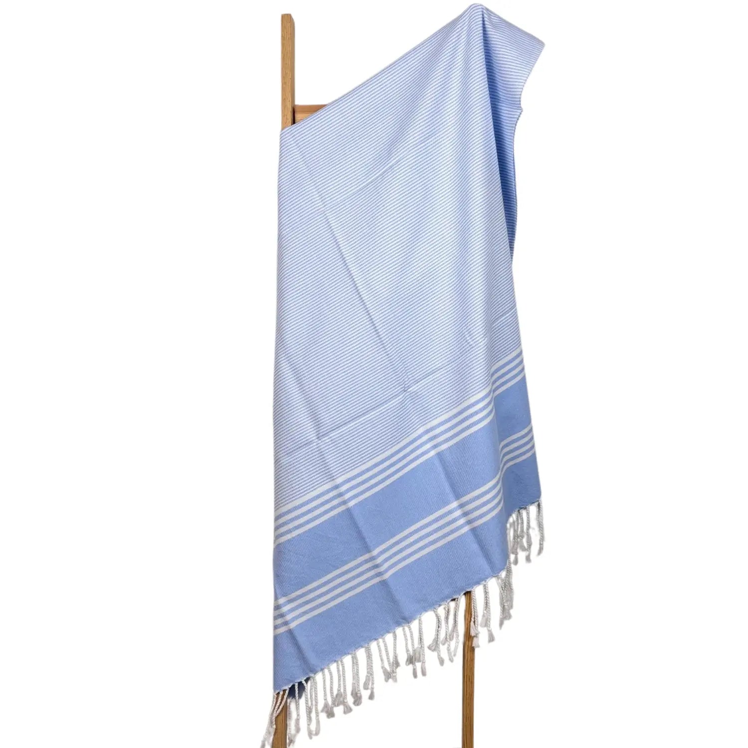Lightweight and absorbent blue Turkish cotton towel with white tassels for spa or beach.