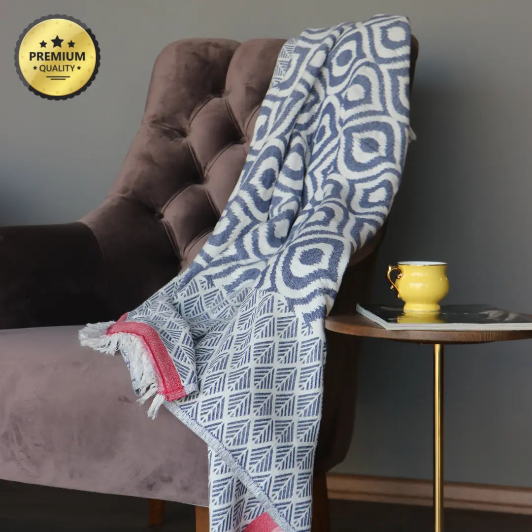 Vibrant denim blue and red striped Turkish cotton plaid draped over furniture, highlighting the high-quality weave and elegant tassel finish.