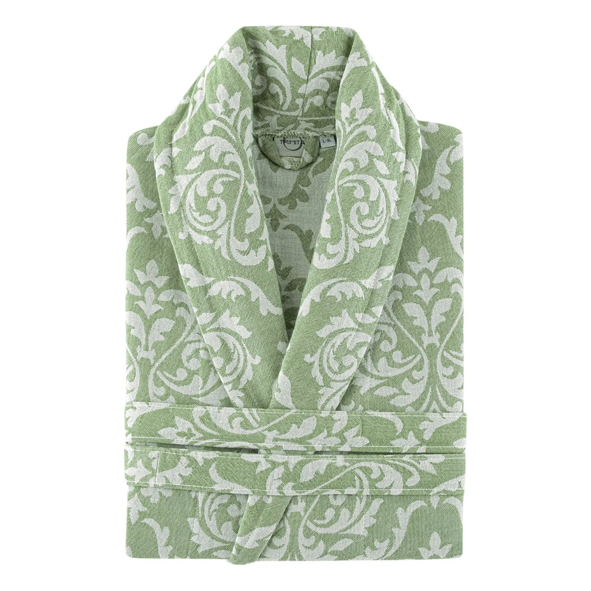 Close-up of a neatly folded sage green organic Turkish cotton robe, highlighting the intricate white damask weave and soft fabric texture.