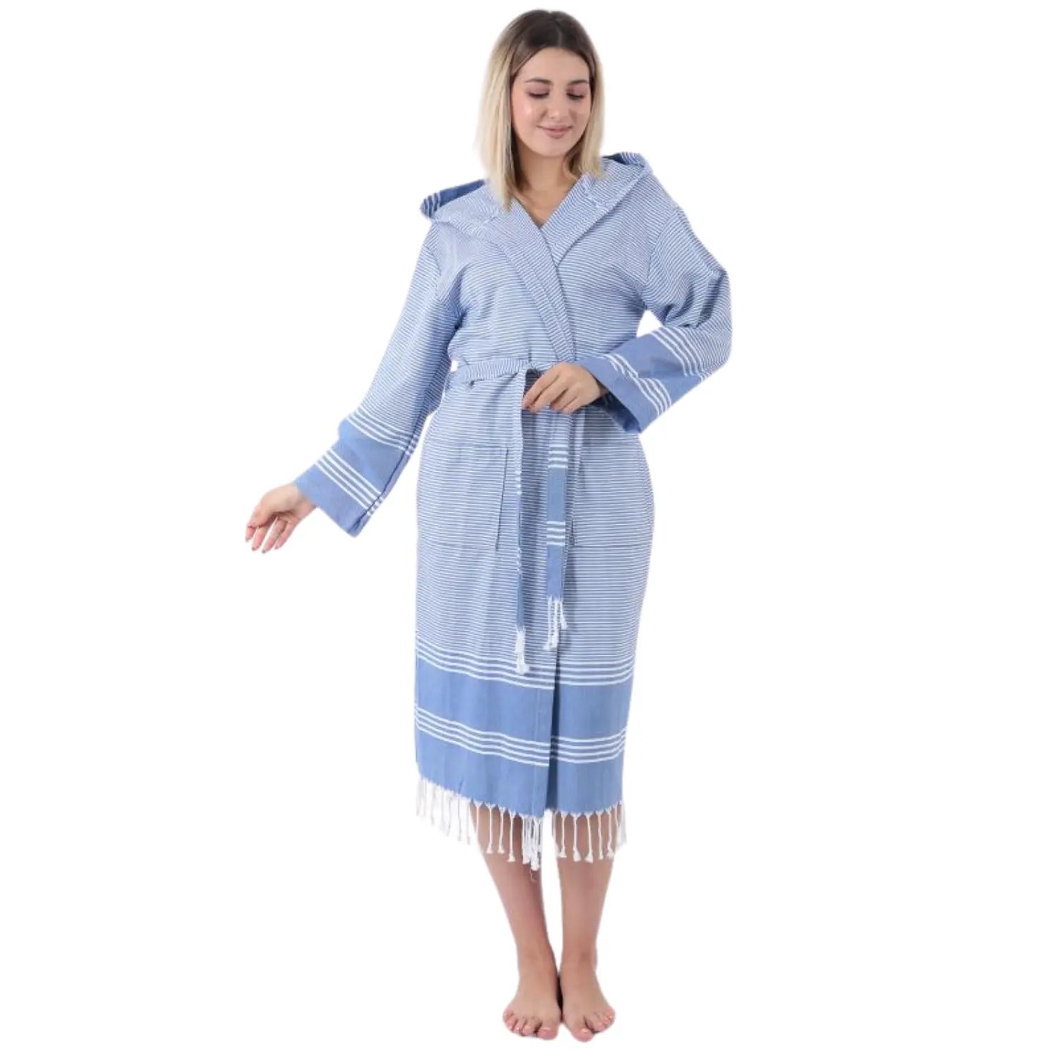 A woman modeling a lightweight blue Turkish spa robe, showing the quick-dry fabric and stylish fringed hem.