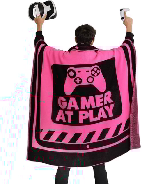 Person wearing a pink and black 'Gamer at Play' cape with gaming controllers.