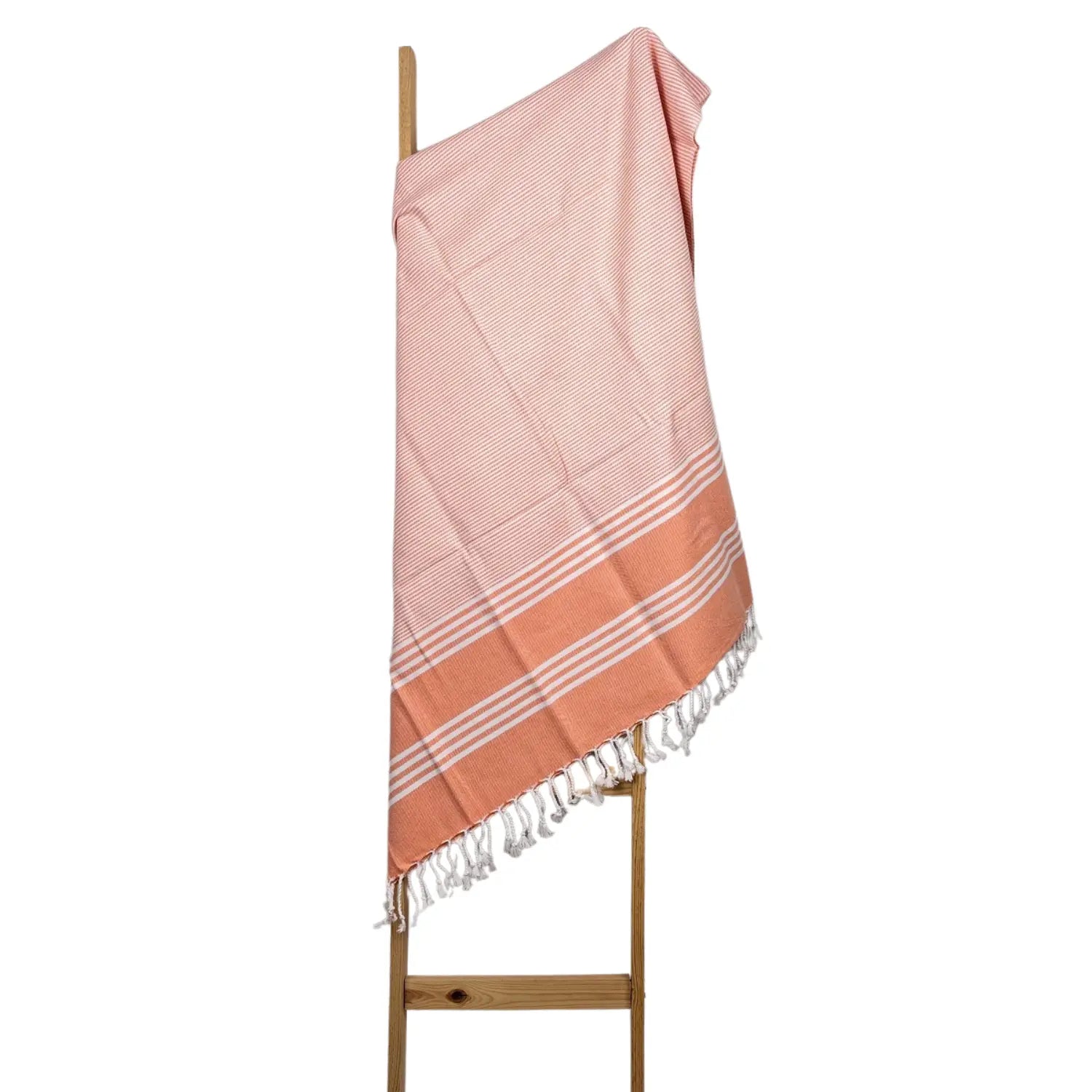 Quick-dry orange Turkish cotton towel hanging on a rustic wooden ladder for bathroom decor.