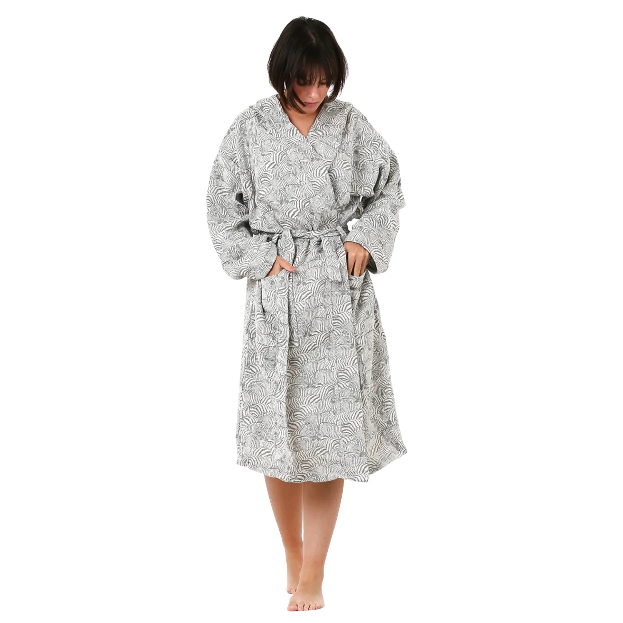 A female model wearing a soft cotton gray zebra print hooded bathrobe with pockets, standing against a neutral background.
