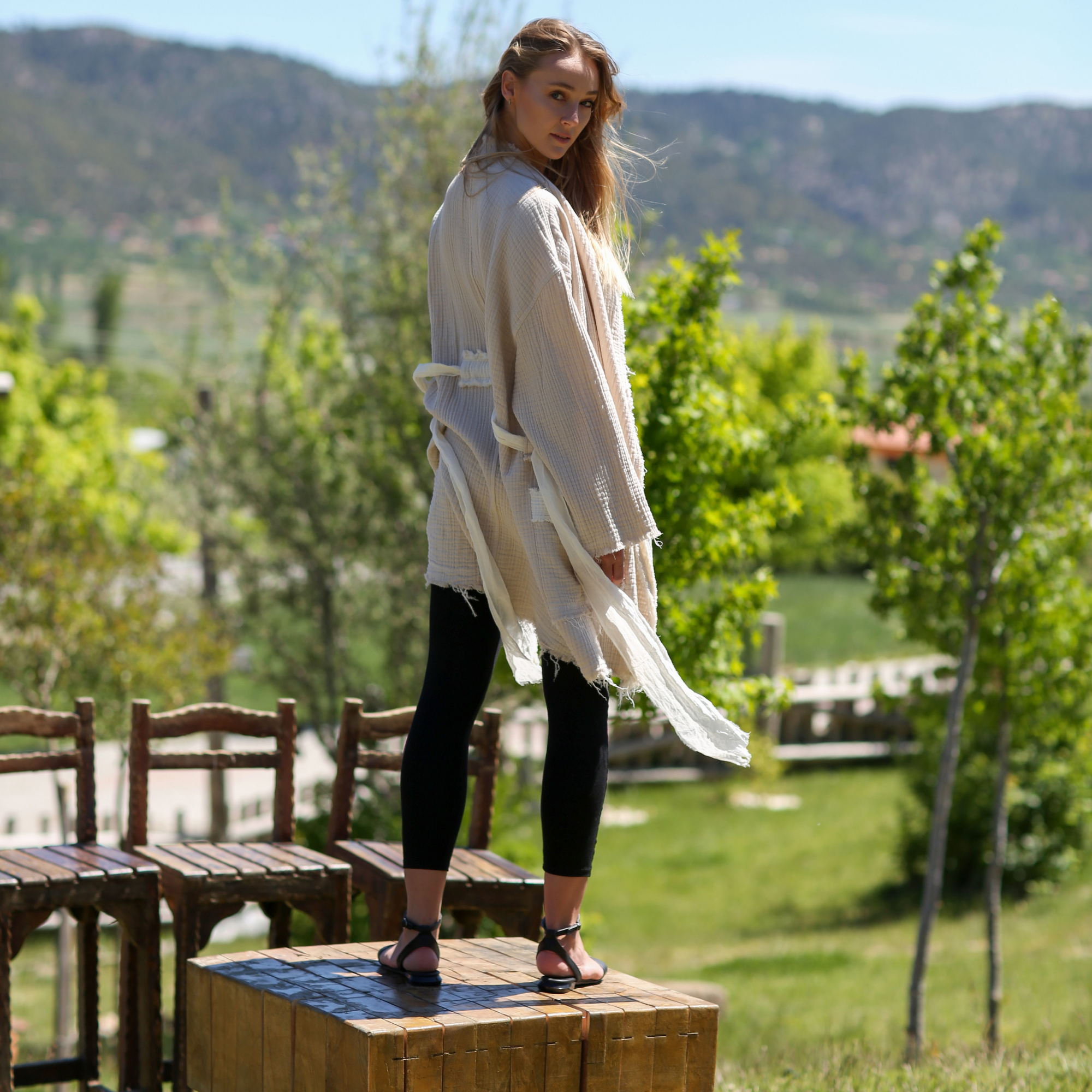 A girl wears natural color muslin jacket, open front, long sleeves,