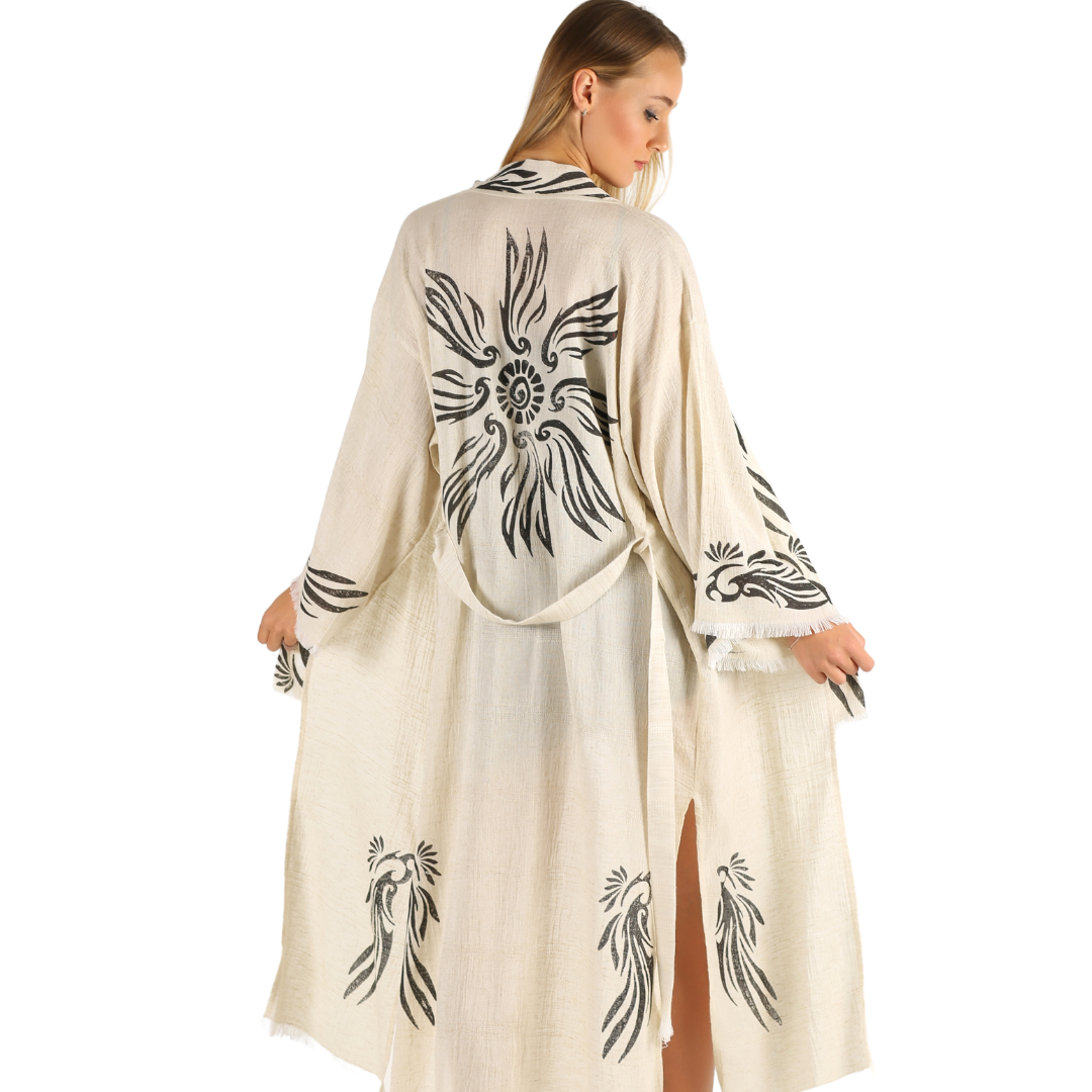 A woman wearing a beige Trimita Angel Kimono with a black and white woodblock print, draped over her shoulders