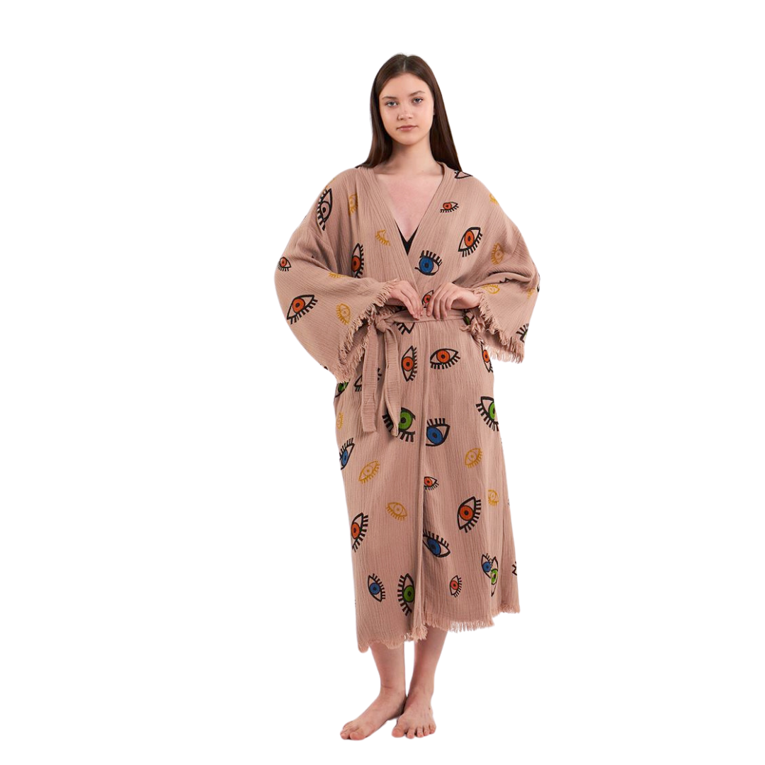 Model facing forward, wearing a beige kimono robe with a colorful eye pattern, posing with hands clasped in front."