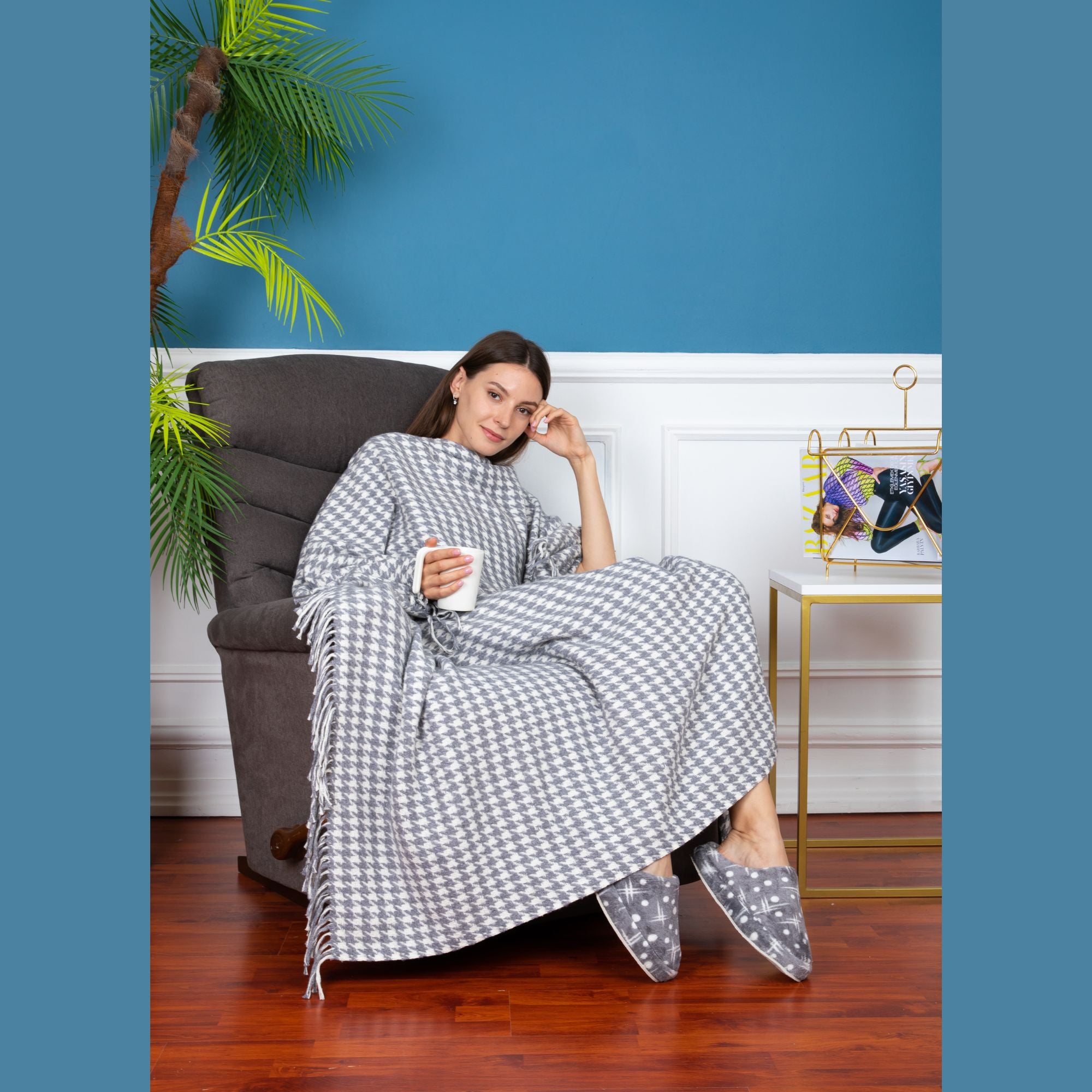 Trimita | Young girl comfortably sitting on a couch, wrapped in the Grey Houndstooth Luxury Throw Blanket, demonstrating its coziness and optimal size.