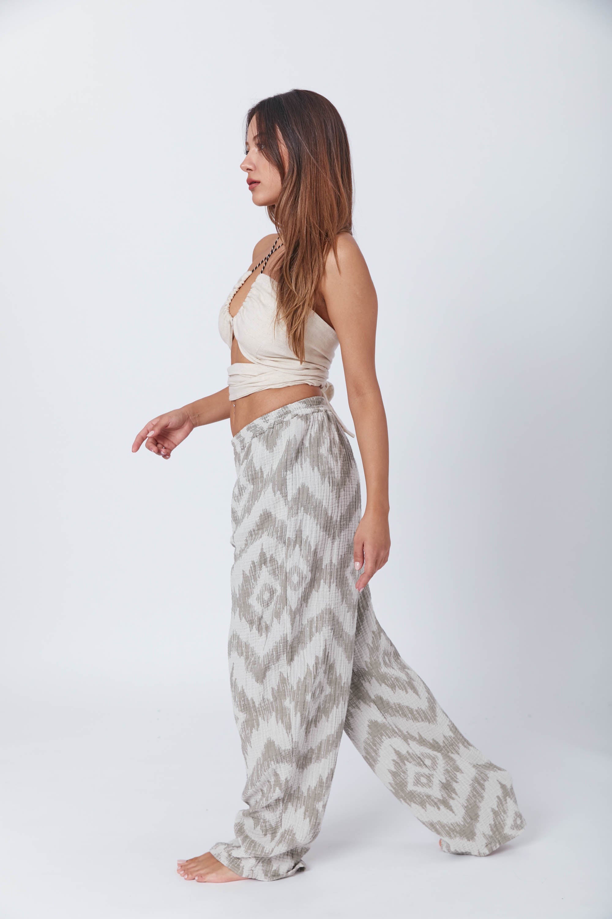 Model wearing a chic, relaxed-fit two-piece set with an ikat-inspired print, paired with a stylish cream halter top featuring a keyhole front design