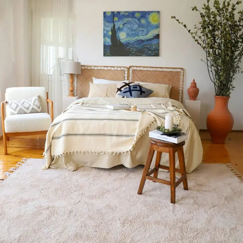 Cozy bedroom with a bed covers Trimita Daphne Bedspread, armchair, and decorative elements. 