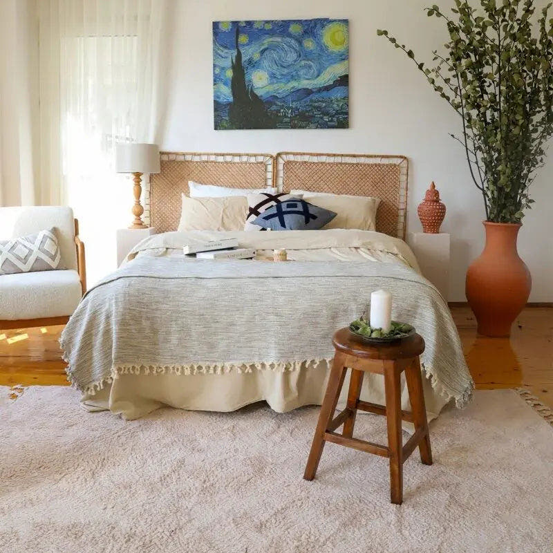 Trimita Duru katoenen plaid, over een bed met franjes langs het voeteneinde