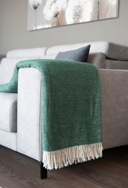 Trimita's green throw blanket draped over a couch arm