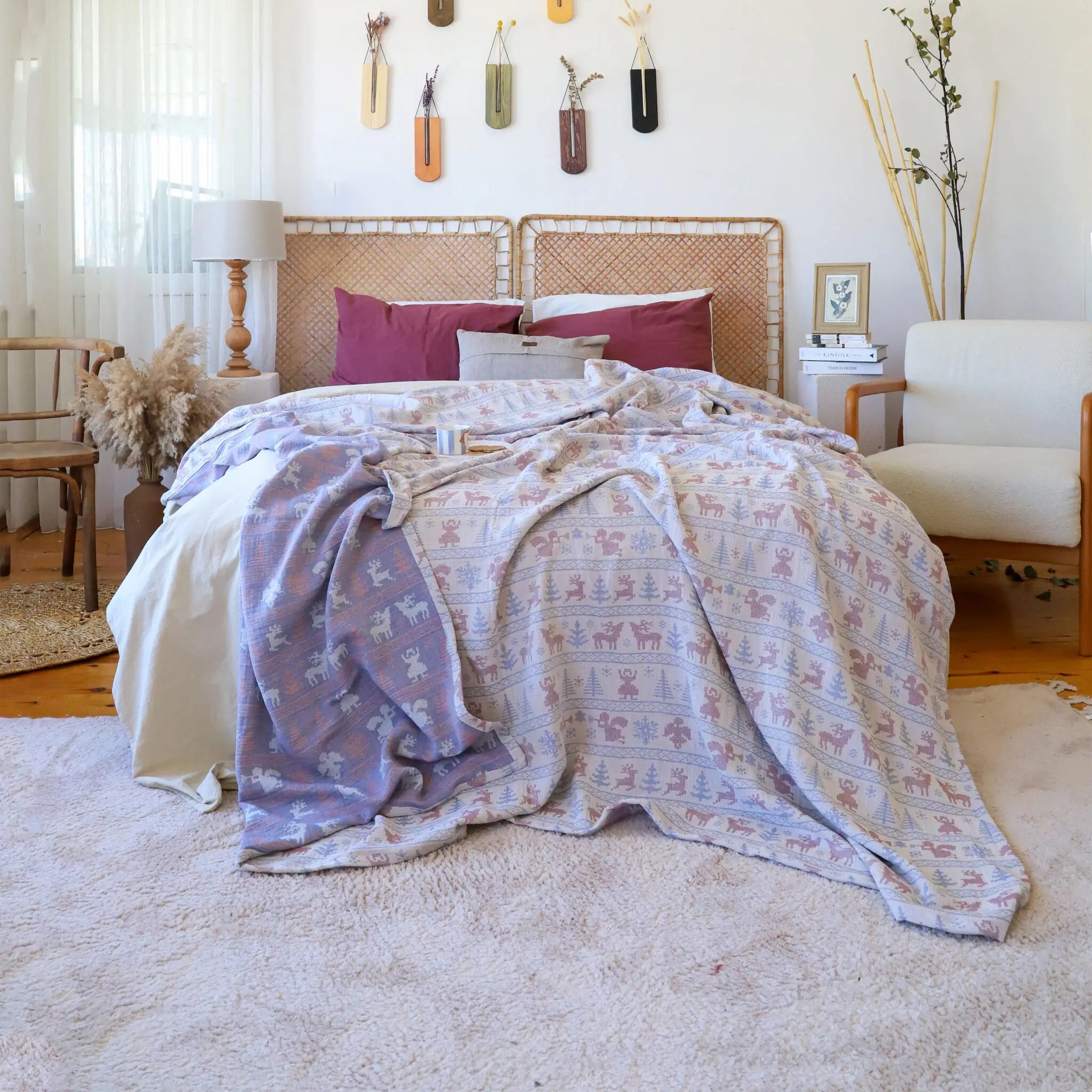 Bedroom with a bed covered in patterned bedding and a Trimita Nordic Deer Bedspread.