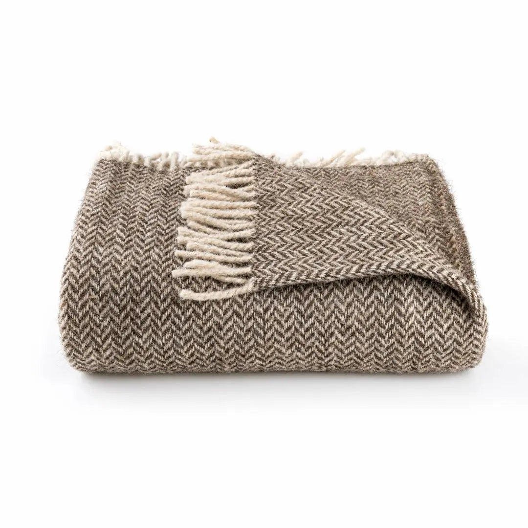 Folded wool blanket in brown and beige herringbone pattern with fringes — natural Turkish wool throw by Trimita, sustainable and soft home textile.