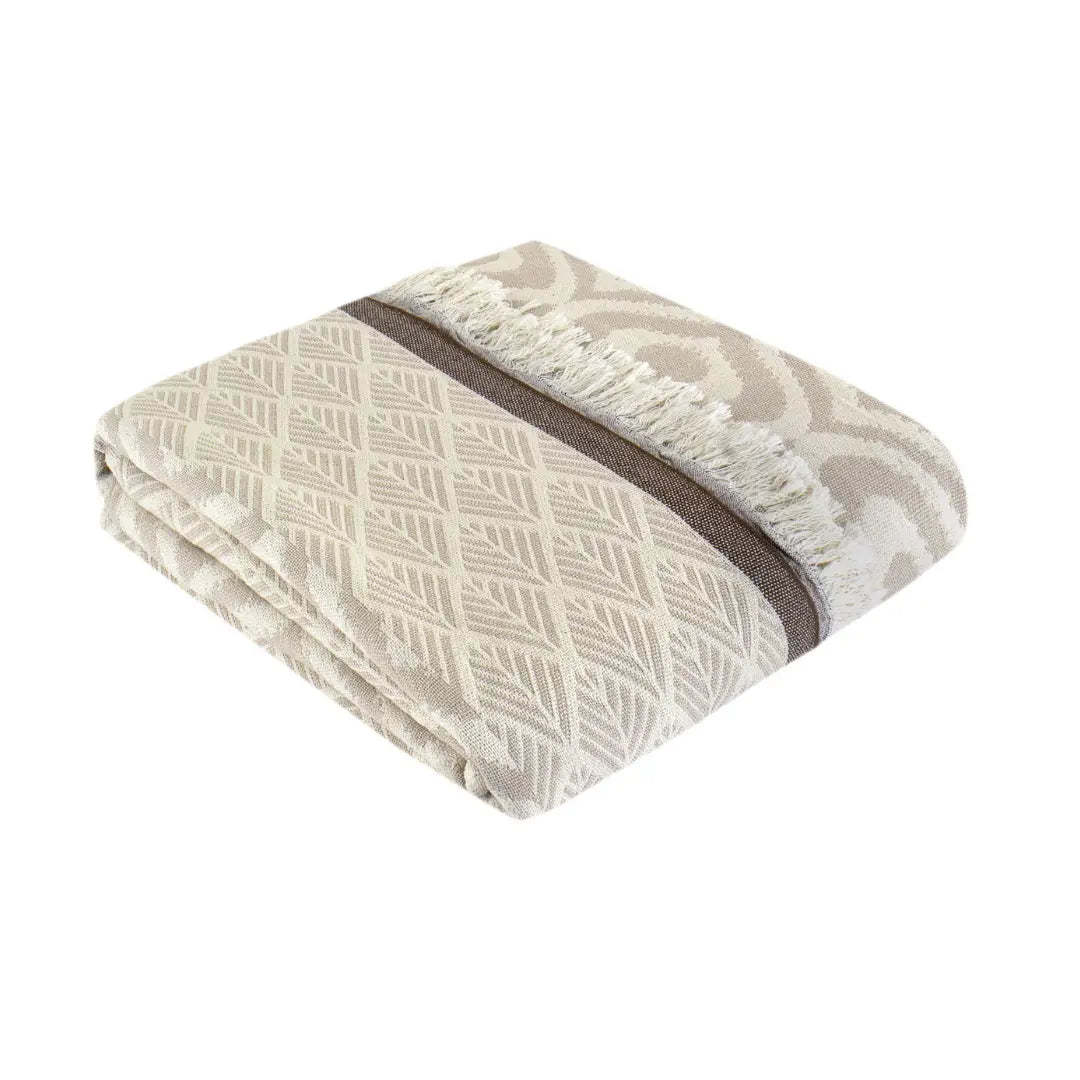 Neatly folded beige and coffee brown cotton throw blanket with ethnic patterns and tassels, highlighting the premium soft texture of authentic Turkish weaving.