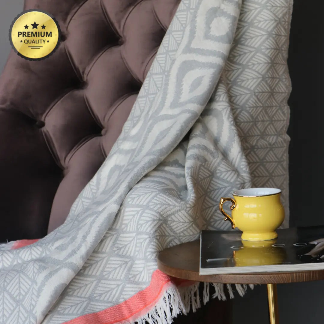 Premium quality grey and red Turkish cotton throw draped over a velvet armchair, perfect for adding a boho farmhouse touch to a cozy reading nook.