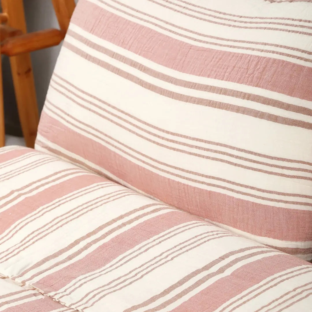 Detailfoto van gestreepte katoen-mousseline stof – Linea dekbedovertrekset met roze en turquoise banen op off-white basis.